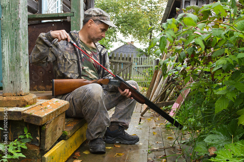 hunter cleans the bore of a shotgun ramrod photo