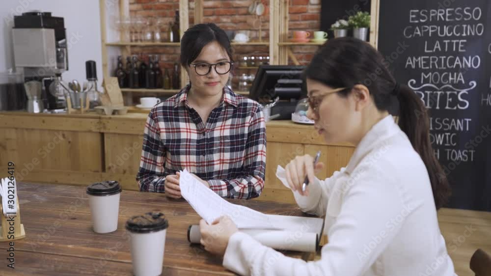 Asian korean woman hr manager holding job interview asking female candidate about working experience while meeting cafe bar. lady boss reading resume while nervous smiling girl applicant sitting by. Asian korean woman hr manager holding job interview asking female candidate about working experience while meeting cafe bar. lady boss reading resume while nervous smiling girl applicant sitting by.