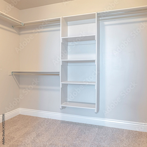 Square Empty white walk in closet with bare shelving