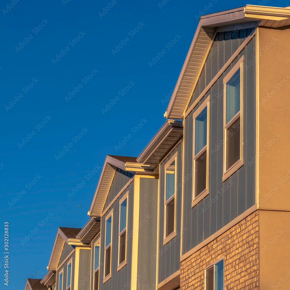 Square frame Townhomes on a neighborhood with vibrant blue sky background on a sunny day Square frame Townhomes on a neighborhood with vibrant blue sky background on a sunny day