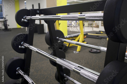 rack with a set of barbells of different weights in the gym, the concept of sports and exercise