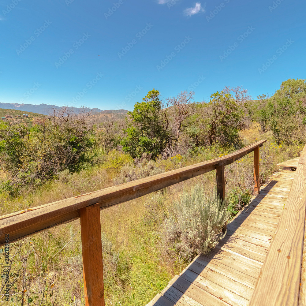 Square frame Wooden walkway with handrails for mountain hikers viewed on a sunny day