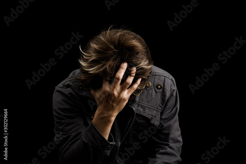 Man sad or cry alone in dark background asia people adult worry unhappy photo