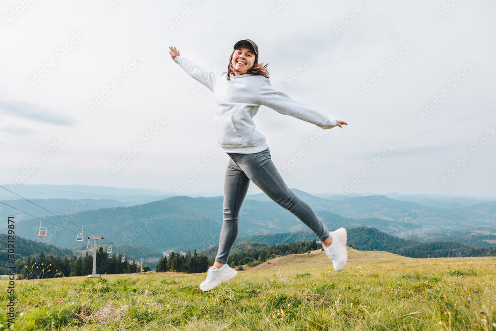 woman jumping at the peak of the mountain beautiful view of valley at background woman jumping at the peak of the mountain beautiful view of valley at background
