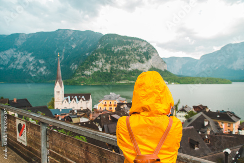 Obraz na płótnie woman in yellow raincoat looking at hallstatt city w salonie