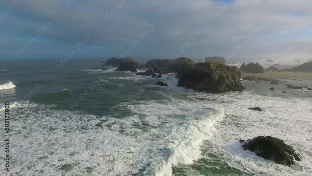 The waves crach into the rugged, rocky landscape of the ocean in this high aerial drone shot The waves crach into the rugged, rocky landscape of the ocean in this high aerial drone shot