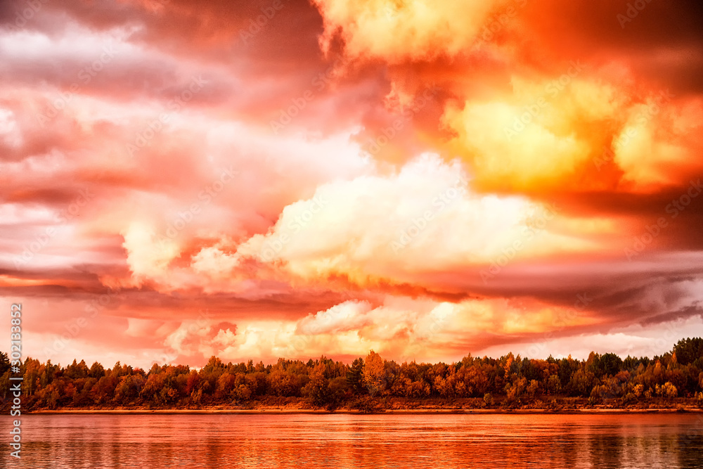 Sky with fantastic, amazing, stormy, disturbing red clouds over the river on a summer or autumn evening - obrazy, fototapety, plakaty 