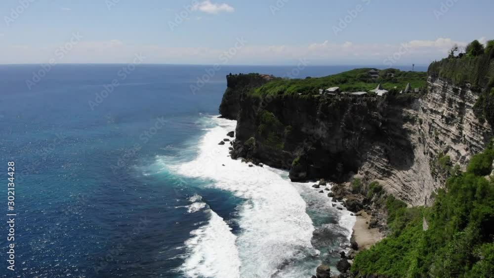 Aerial: flying trough the ocean, waves breaking on the cliff, Uluwatu, Bali Aerial: flying trough the ocean, waves breaking on the cliff, Uluwatu, Bali