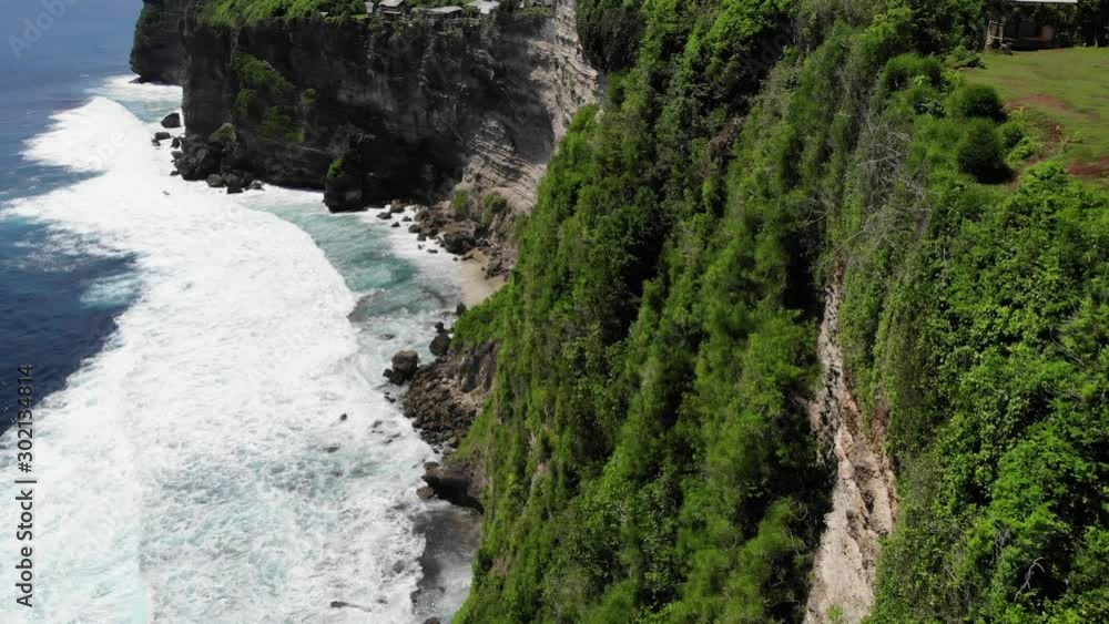 Aerial: flying trough the ocean, waves breaking on the cliff, Uluwatu, Bali Aerial: flying trough the ocean, waves breaking on the cliff, Uluwatu, Bali