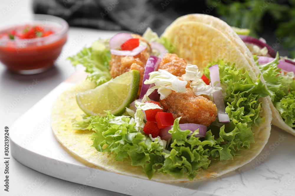 Delicious fish tacos served on light grey table, closeup