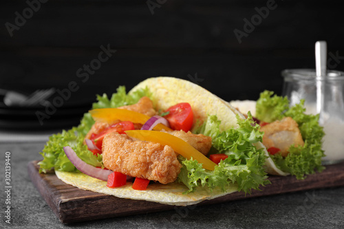 Delicious fish tacos served on grey table, closeup