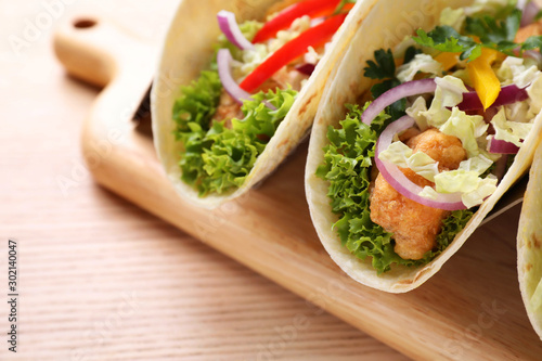 Delicious fish tacos served on wooden table, closeup