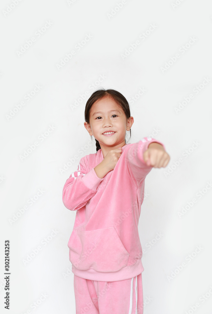 Portrait of beautiful little Asian child girl in pink tracksuit or sport cloth with fight stance over white background. Portrait half-length of kid girl. Confident concept. Portrait of beautiful little Asian child girl in pink tracksuit or sport cloth with fight stance over white background. Portrait half-length of kid girl. Confident concept.