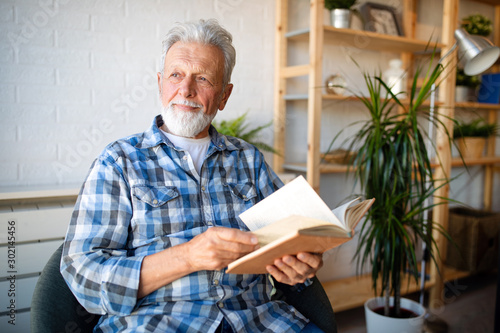 Konstfotografi Happy senior man reading book at home