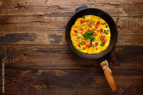 Slika na platnu omelet with old cast iron pan on wooden background with copy space