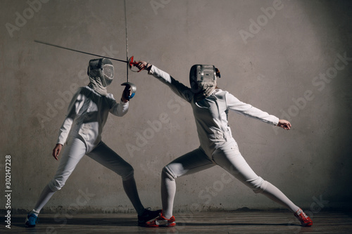 Slika na platnu Fencer  with fencing sword. Fencers duel concept.