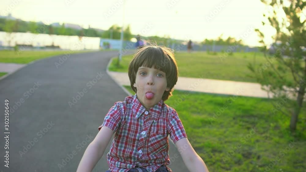 Child little boy riding bicycle on road street at sunset light of summer sunny day. Happy boy kid cycling bike, having fun outdoors nature. Active sport happy family leisure holidays, Slow motion Child little boy riding bicycle on road street at sunset light of summer sunny day. Happy boy kid cycling bike, having fun outdoors nature. Active sport happy family leisure holidays, Slow motion
