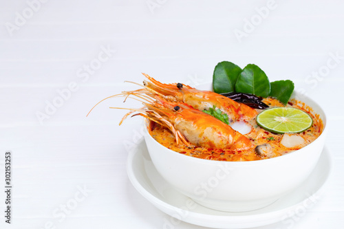 Obraz na plátne Tom Yum Goong or Shrimp soup spicy sour Soup Traditional food in Thailand contains chili, lime, ginger, galangal, lemongrass, lime leaf, from top view on a white wood background