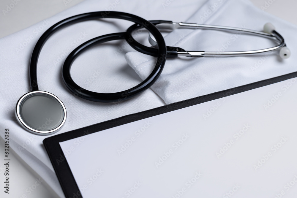 Stethoscope, pen and notepad on white background. Heart treatment concept, cardiology. Stethoscope, pen and notepad on white background. Heart treatment concept, cardiology.