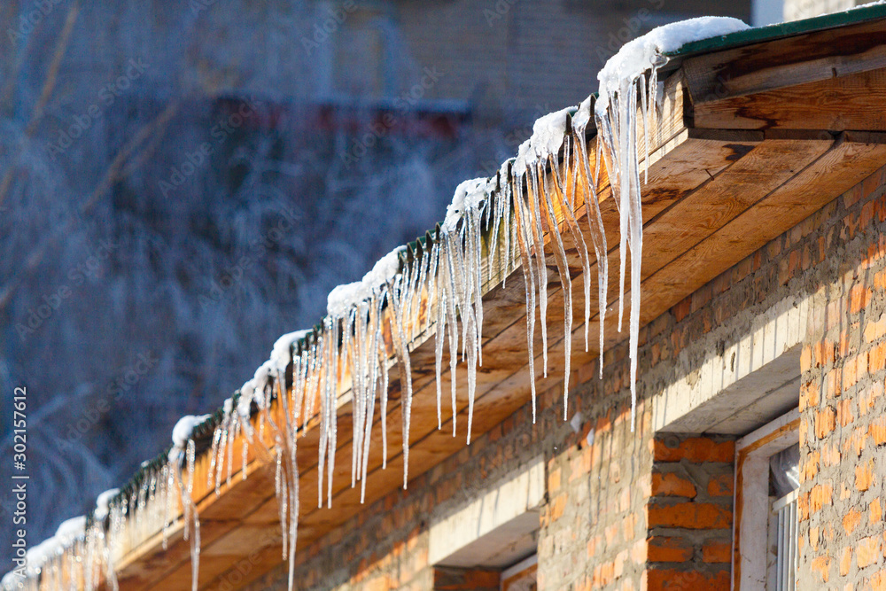 icicles which are hanging down from a roof - obrazy, fototapety, plakaty 