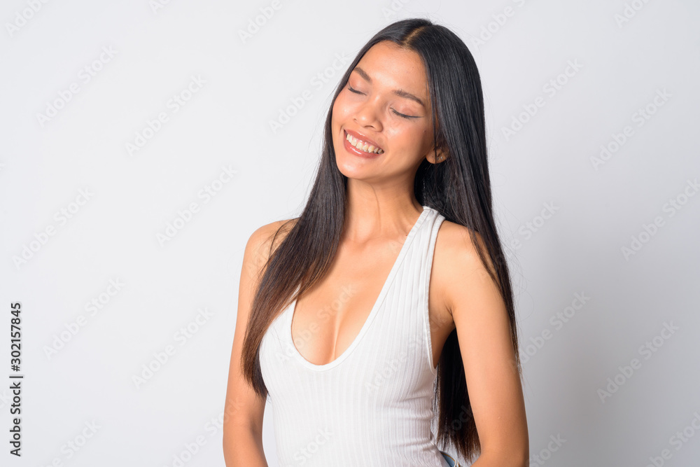 Portrait of happy young beautiful Asian woman relaxing with eyes closed Portrait of happy young beautiful Asian woman relaxing with eyes closed
