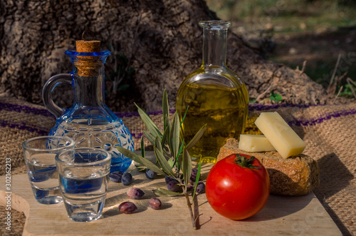 Obraz na plátně Cretan food with virgin olive oil, Olives,Cretan Barley Rusks, local cheese and carafe of cretan raki
