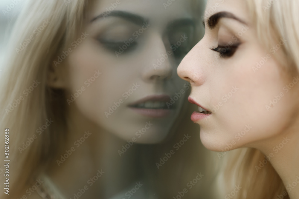 Portrait of a beautiful blonde girl. Reflection in the mirror. Portrait of a beautiful blonde girl. Reflection in the mirror.