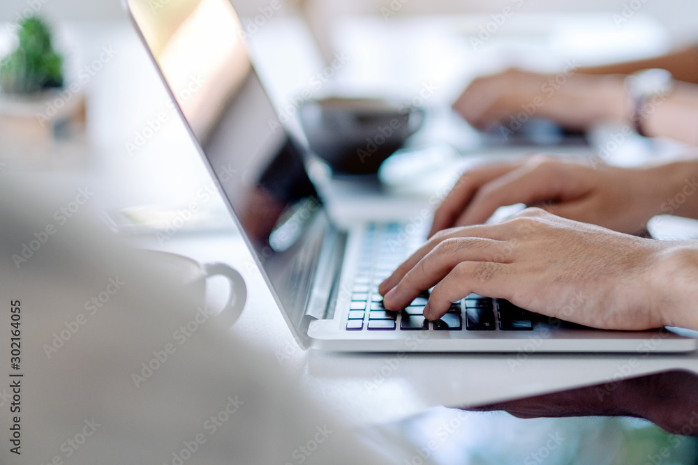 Businessman using and working on laptop computer together in office Businessman using and working on laptop computer together in office