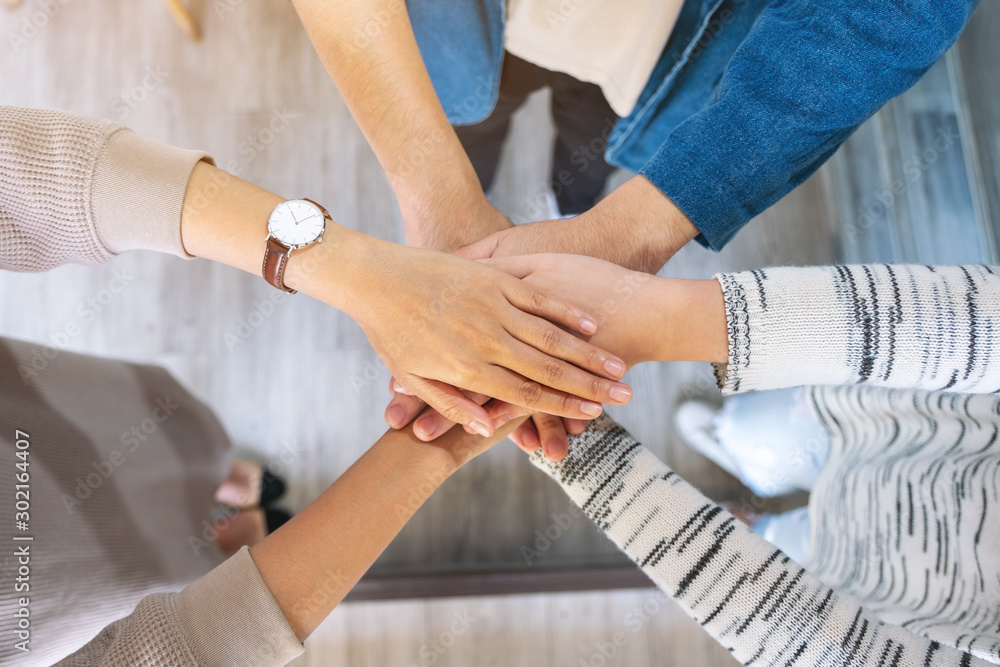 Fototapeta premium Top view image of people putting their hands in stack together