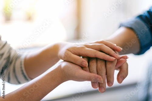 A man and a woman holding each other hands for comfort and sympathy