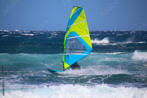 Windsurfer among the waves of turquoise color at the Atlantic Ocean (El Medano, Spain) photo