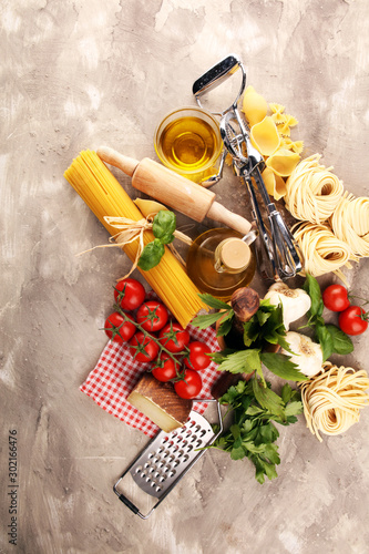 Pasta, vegetables, herbs and spices for Italian food on rustic table