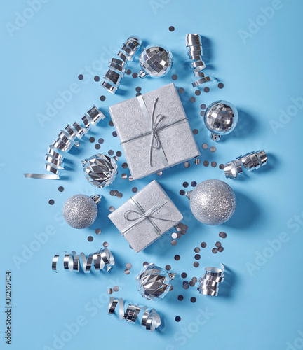 Silver christmas decorations on blue background.