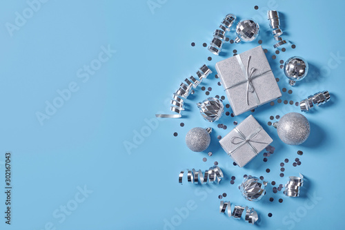 Christmas gift boxes with ribbon and decorations on blue background.