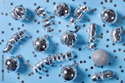 Silver christmas decorations on blue background.