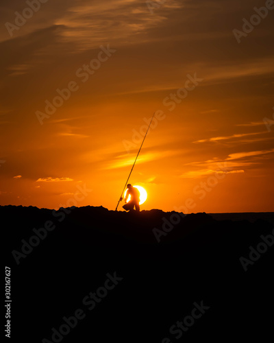 persona pescando en la puesta del sol © mavericksun