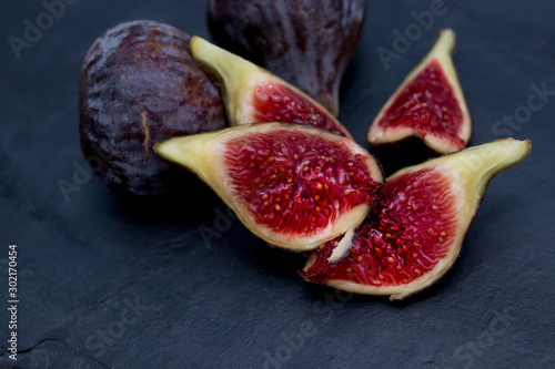 open natural black figs isolated on black background