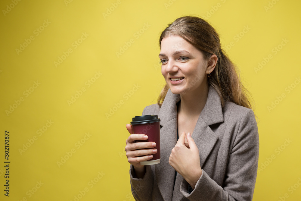 Glamor woman with a drink of coffee on a yellow background Glamor woman with a drink of coffee on a yellow background