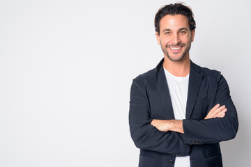 Portrait of happy handsome Hispanic businessman smiling with arms crossed