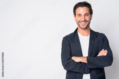 Portrait of happy handsome Hispanic businessman smiling with arms crossed