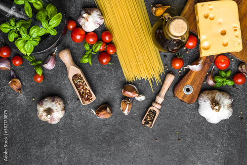 Italian food background. Cooking ingredients for spaghetti: tomatoes, basil, olive oil, cheese, garlic, spices