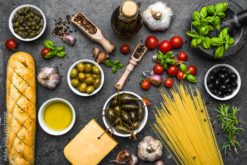 Mediterranean diet background or italian food ingredients on dark slate.