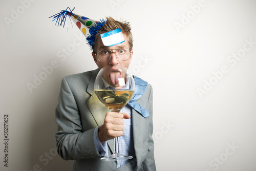 Obraz na plátne Drunk businessman wearing a New Year's Eve party hat with a name tag stuck to hi