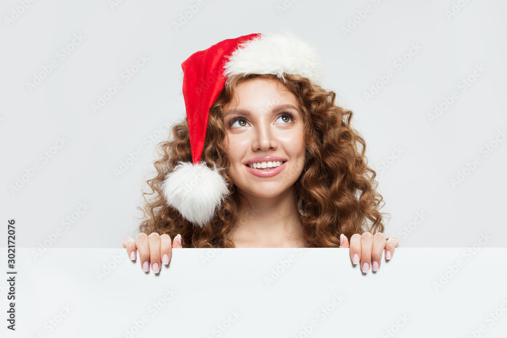 Christmas woman in Santa hat holding white empty singboard card Christmas woman in Santa hat holding white empty singboard card