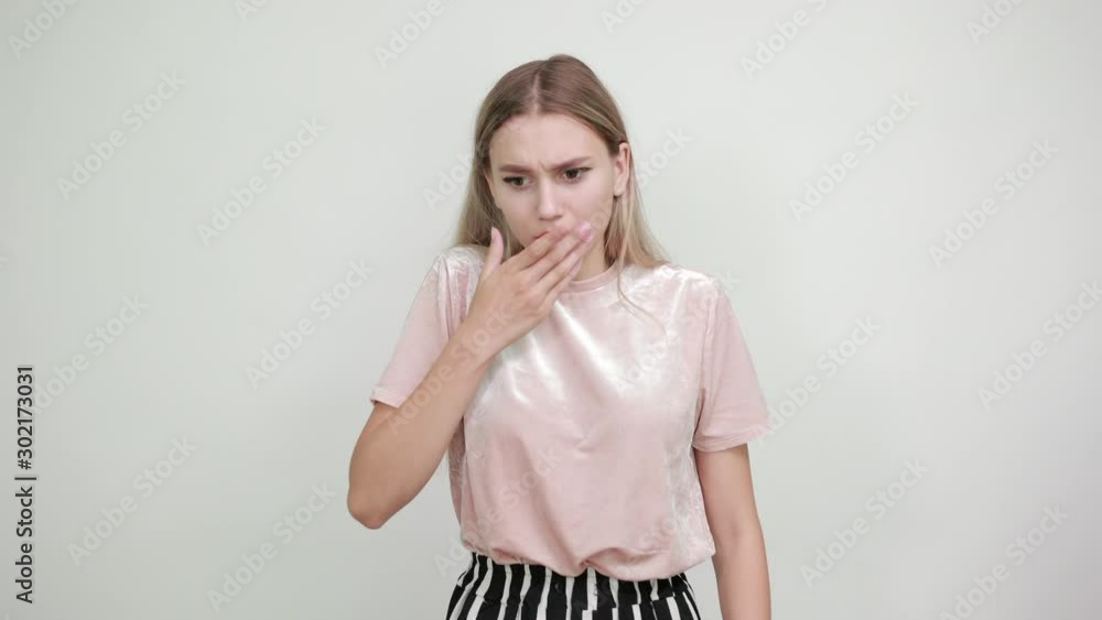 Young attractive blonde woman wearing pastel clothes, over isolated wall with surprise facial expression, covering mouth with hands over isolated white background Young attractive blonde woman wearing pastel clothes, over isolated wall with surprise facial expression, covering mouth with hands over isolated white background