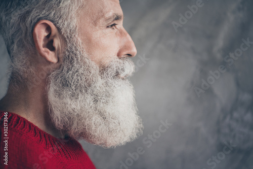 Cropped closeup profile photo of serious aged guy looking empty space deeply thinking wear red knitted pullover hipster santa outfit isolated concrete grey wall background