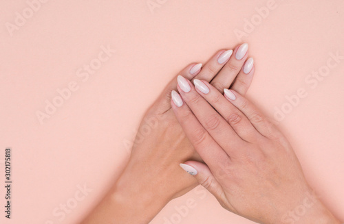 Beautiful stylish female manicure on a pink background.