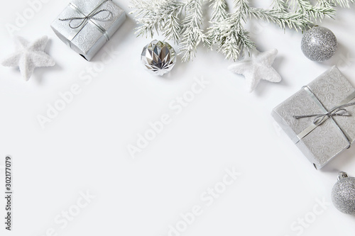 Christmas gift box with silver ribbon and bow, christmas decorations on white background.