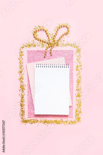 Christmas flat lay. Gift box of gold glitter pattern with copy space for text on a pink background. Christmas festive mockup © shintartanya