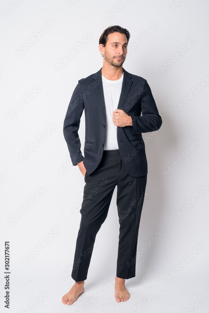 Full body shot of handsome Hispanic businessman thinking Full body shot of handsome Hispanic businessman thinking